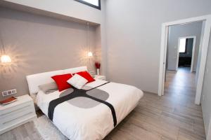 a bedroom with a large white bed with red pillows at Catalunya Casas Modern Marvel,15 min to Costa Brava beaches! in Sils +26 photos