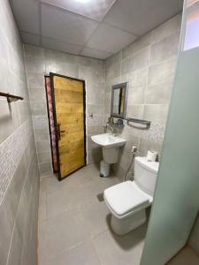 a bathroom with a toilet and a sink and a door at Wadi rum Rozana camp in Wadi Rum +82 photos