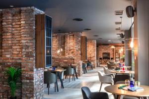 a restaurant with tables and chairs and a brick wall at Park Hotel & Spa in Skopje