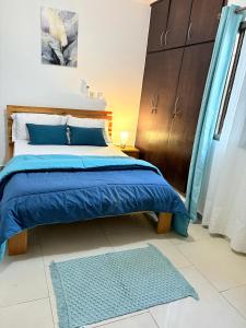 a bedroom with a blue bed and a blue rug at Résidence ephrata in Cocody