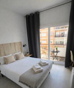 a bedroom with a bed and a large window at CASA MILA SV19 guesthouse in Alicante