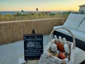 a basket of food and a sign on a patio at Georges Houses Mani in Riglia