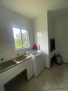 a bathroom with a sink and a washing machine at Casa em itapema fácil acesso e bem localizada in Itapema +16 photos