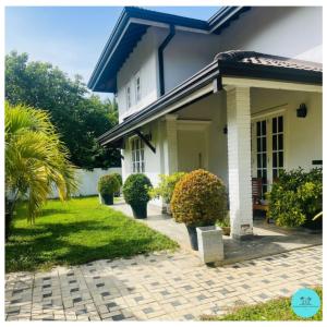 a white house with a brick driveway at Nuwan Home Vacation Villa in Wennappuwa +2 photos