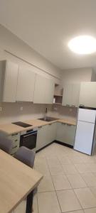 an empty kitchen with white cabinets and a table at Casa Oliva in Ermoupoli