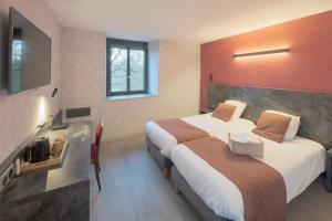 a hotel room with two beds and a fireplace at Logis Hostellerie la Chaumière in Arsonval