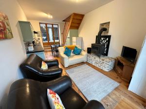 a living room with leather furniture and a fireplace at Gites Le Chezeau in Saint-Amand-Magnazeix