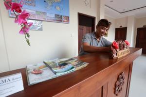a man standing at a counter with a cake at Rama House in Ubud