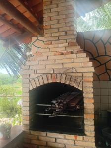 an outdoor pizza oven with a brick fireplace at Rancho Colcha de Retalho in Caucaia