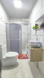 a bathroom with a toilet and a sink and a shower at Quarto Casal Com AR Condicionado e Banheiro Privativo in Guaíra +18 photos