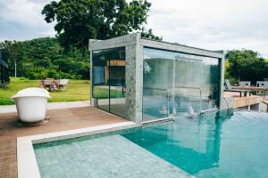 a glass house with a pool in the backyard at Roga Village in Atibaia