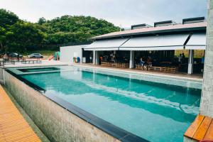 a swimming pool in front of a building at Roga Village in Atibaia