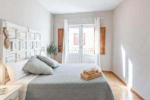 a white bedroom with a large bed with two pillows at Ca'n Tosca Jávea in Jávea
