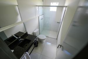 a bathroom with a shower and a toilet and a sink at Hotel Pedra Moura in Vacaria