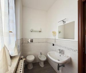 a white bathroom with a sink and a toilet at Residenza Bibiena - Lake View - in Mantova +33 photos