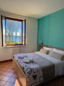 a bedroom with a large bed with a window at Residenza Bibiena - Lake View - in Mantova