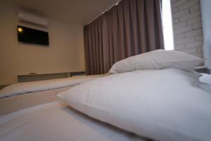 a bedroom with a bed with pillows and a television at Hotel Pedra Moura in Vacaria