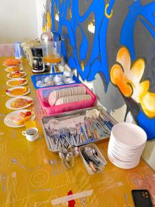 a table with plates and utensils on it at Vang Vieng Freedom View Hostel in Ban Khouaphan +6 photos