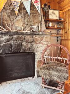 a stone fireplace with a chair in front of it at Campo Carnelian in Carnelian Bay