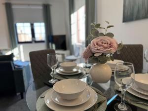 a glass table with a vase with a flower on it at Central 1BR Apt with Parking in Auchterarder