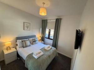 a bedroom with a bed with two towels on it at Central 1BR Apt with Parking in Auchterarder