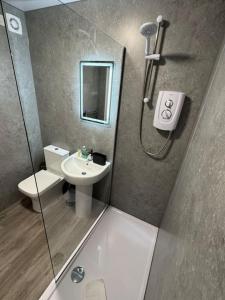 a small bathroom with a shower and a sink at Central 1BR Apt with Parking in Auchterarder +23 photos