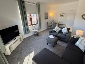 a living room with a couch and a tv at Central 1BR Apt with Parking in Auchterarder