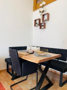 a dining room table with two black chairs around it at Das CLASSIQUE Galerieappartement 50qm - Elegant und geräumig wohnen - Espressomaschine, Airfryer, Balkon, Vierbeinerfreundlich, Parkgarage -AppHaus Poseidon in Bad Griesbach