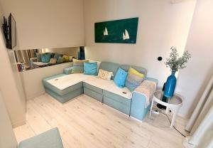 a living room with a blue couch and a table at Spacious studio apartment in the heart of Cascais historic center in Cascais