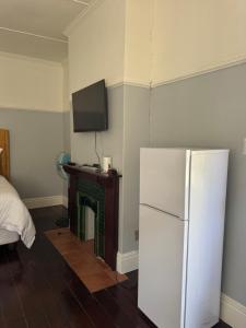 a room with a refrigerator and a tv on the wall at Legacy lodge in Goodwood