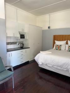 a bedroom with a large bed and a kitchen at Legacy lodge in Goodwood