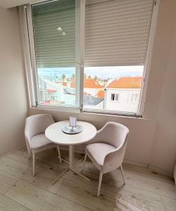 a table and two chairs in a room with a window at Spacious studio apartment in the heart of Cascais historic center in Cascais +49 photos