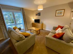 a living room with two couches and a television at Kirkwall town centre apartment 3 in Kirkwall