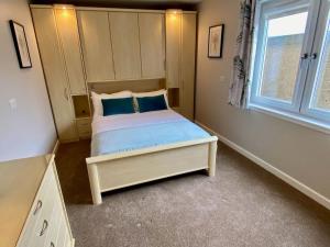 a bedroom with a bed with blue pillows and a window at Kirkwall town centre apartment 3 in Kirkwall