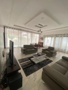 a large living room with couches and a tv at Le grand luxe in Cotonou