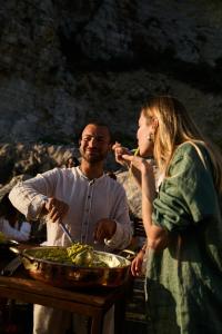 a man and a woman standing next to a bowl of food at Hotel Vista di Capri in Massa Lubrense
