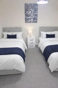 a bedroom with two twin beds and a night stand at Golden Stay in Wyken