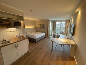 a room with a bed and a kitchen with a table at pepb Schulungshotel in Sarstedt +36 photos