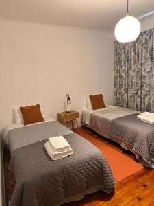 a room with two beds and a table with a lamp at Casa do Alto da Torre in Abrantes