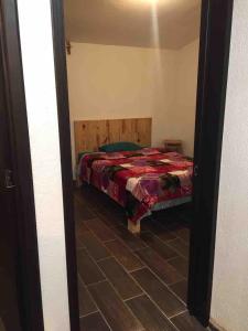 a bedroom with a bed and a tiled floor at Casa Sustentable Monarca Angangueo in Mineral de Angangueo