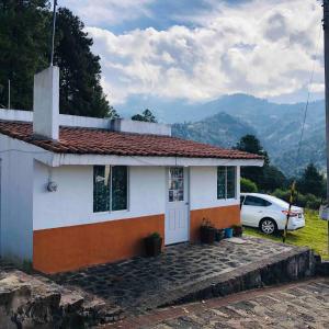 a small house with a car parked in front of it at Casa Sustentable Monarca Angangueo in Mineral de Angangueo +3 photos