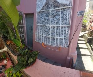 a pink house with a window and some plants at Rio Private Budget Suite & Easy Transport Access in Rio de Janeiro