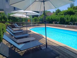 a pool with lounge chairs and umbrellas next to a swimming pool at A l'ombre du Lilas 3 chambres - terrasse - possibilité Spa privatif sur place - possibilité piscine située à 20 minutes in Épinal