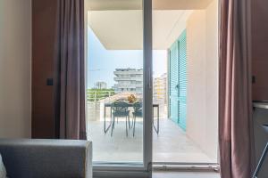 a room with a balcony with a table and a glass door at Penelope al mare 20 in Alba Adriatica
