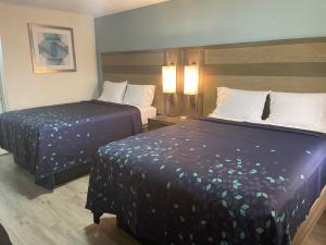 a hotel room with two beds in a room at Executive Inn & Suites in Beaumont +10 photos