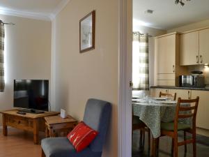 a living room with a table and a dining room at Ness-Side Apartment in Inverness