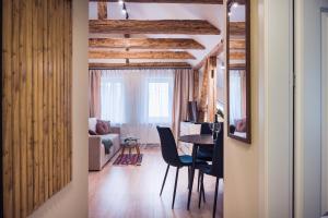 a room with a table and chairs and a living room at Willa na Dębowej in Katowice