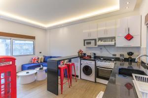 a kitchen with white cabinets and a stove top oven at City Rental London theme in Batroûn