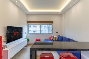 a living room with a blue couch and a tv at City Rental London theme in Batroûn
