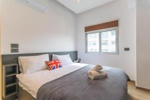 a bedroom with a bed with a stuffed animal on it at City Rental London theme in Batroûn
